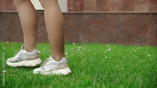 Legs of a young woman walking on the grass