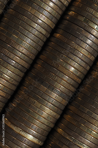 Wallpaper from stacks and edges of yellow coins placed at an angle diagonally across the shot. Ten Russian rubles. Dark vertical background on economic or financial topic. Macro