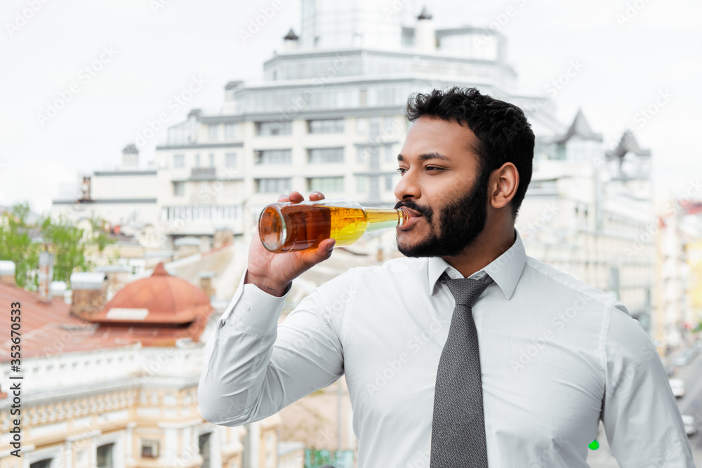 bearded african american man in medical mask drinking beer outside bearded african american man in medical mask drinking beer outside