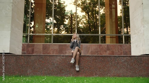Beautiful blonde woman eating ice cream outside 