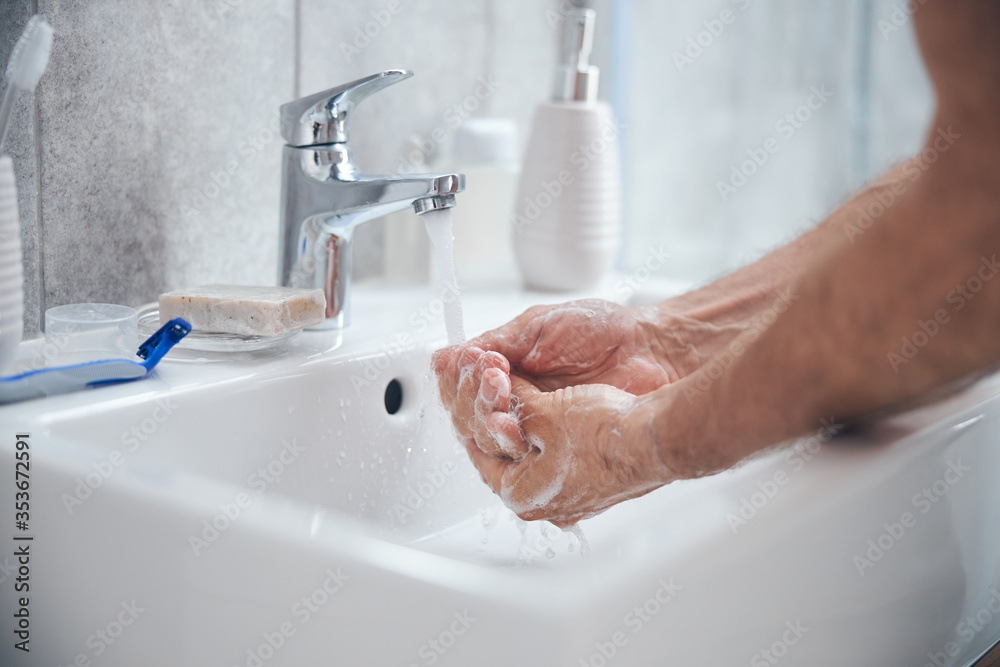 Man holding his cupped palms under running water Man holding his cupped palms under running water