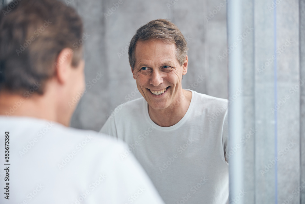 Blond joyous male standing in a bathroom Blond joyous male standing in a bathroom