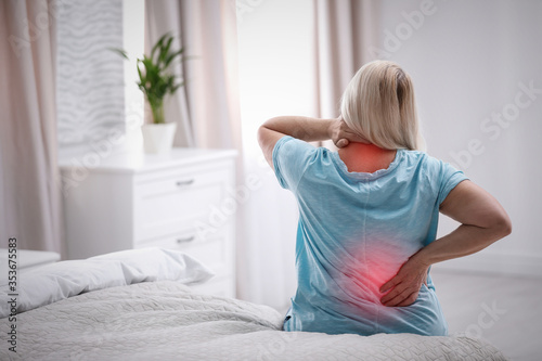 Senior woman suffering from pain in back at home photo