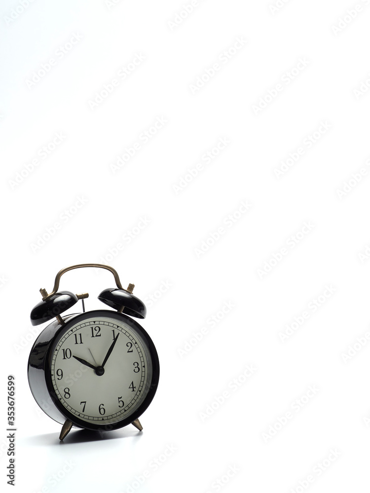 Black alarm clock on white background.