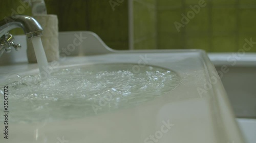 Water flowing into a clogged sink. It can not leave because of a blockage in the pipe and begins to overflow. Plumbing in need of repair.