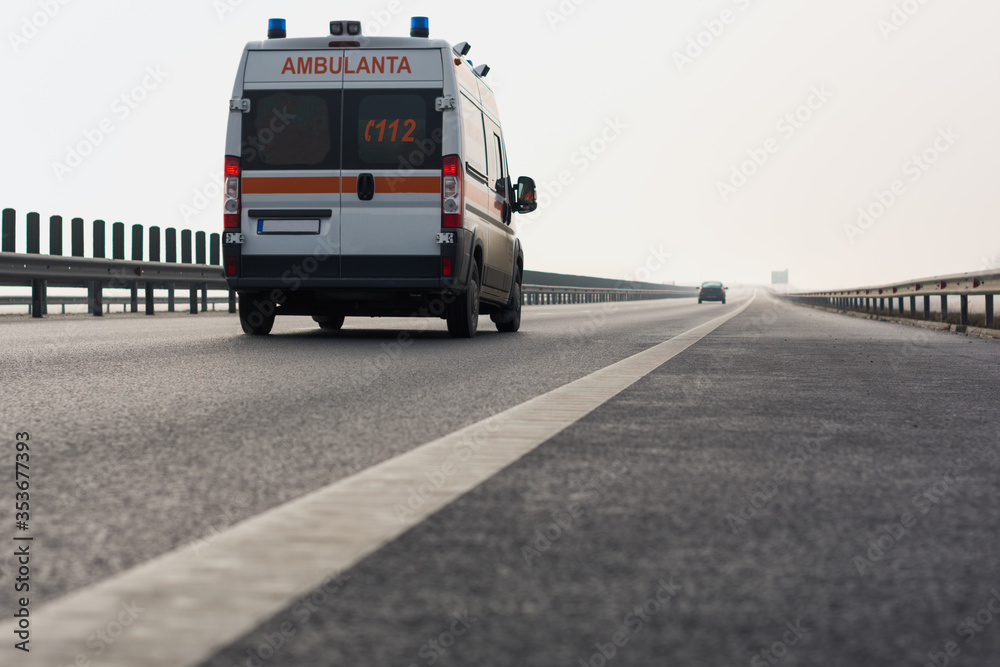Medical ambulance travels at high speed on the highway in foggy conditions