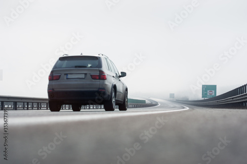 Car travels at high speed on the highway in foggy conditions