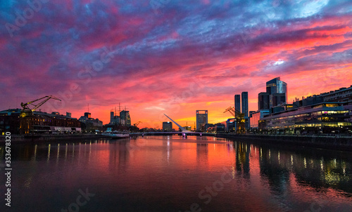 Puerto Madero Bridge and city by the river  during sunrise  with colorful clouds. 