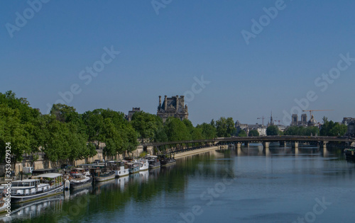 view of the Seine river with two banks and boats on it and a bridge in Paris