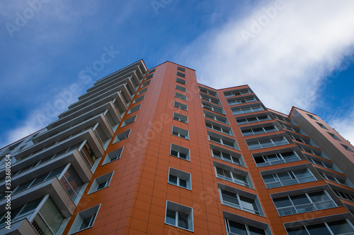 Orange multi-storey building on sky background.