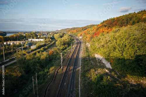 View from the top to the railway. Colorful forest along the road. Gold autumn.