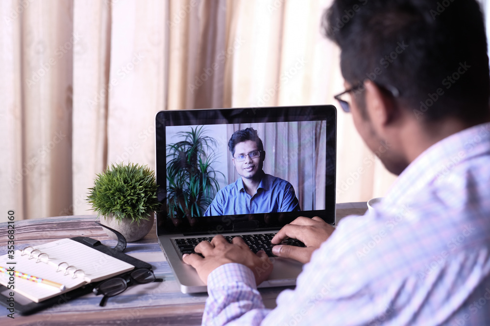 Back view of business man in video conference discussing strategy Back view of business man in video conference discussing strategy