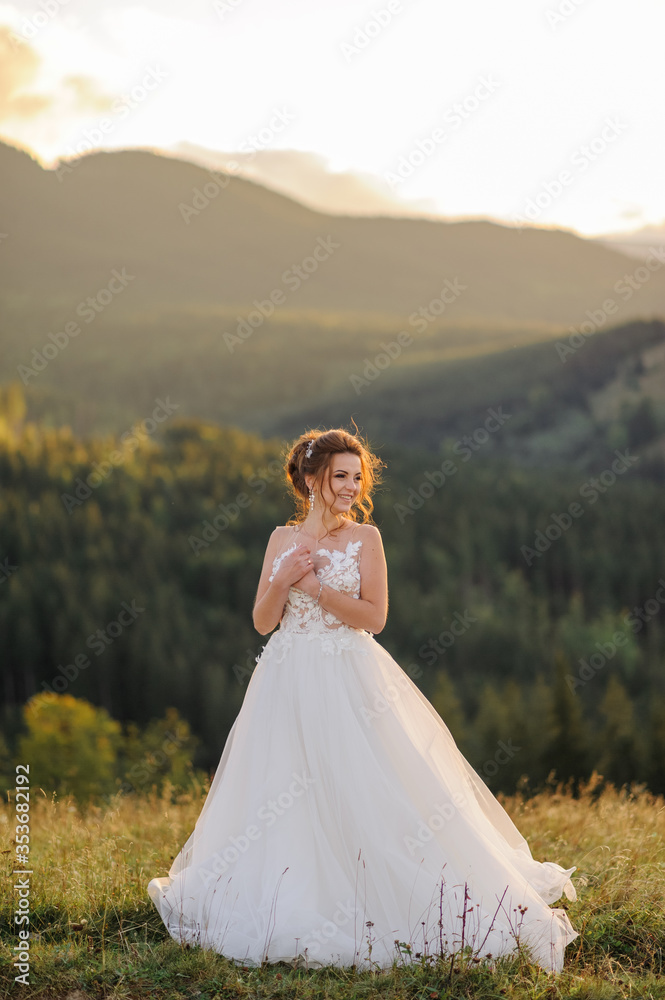 The bride herself poses against the backdrop of the mountains at sunset.