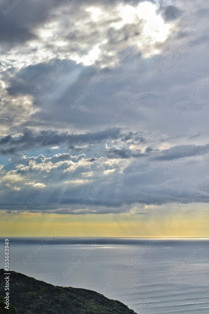 Sun shines through rain clouds over Tasman sea horizon Sun shines through rain clouds over Tasman sea horizon
