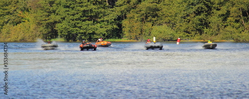 A many inflatable motor boats on speed start line, summer water outdoor sport competition