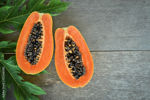 Half cut papaya placed on a wooden background.Papaya fruit on wooden background.close up papaya image. 