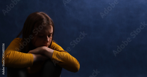 Teen girl sitting hugging his hands. Adolescent psychological and social problems.