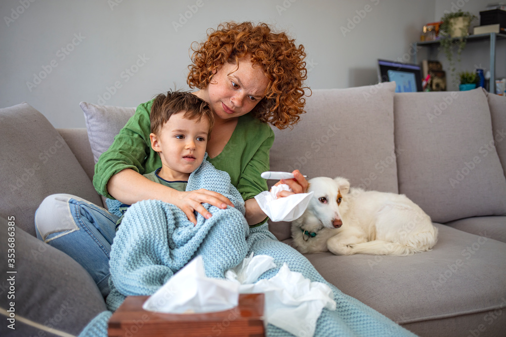 Sick boy with thermometer laying in bed and mother hand taking temperature. Mother checking temperature of her sick son who has thermometer. Sick child with fever and illness in bed. Sick boy with thermometer laying in bed and mother hand taking temperature. Mother checking temperature of her sick son who has thermometer. Sick child with fever and illness in bed.