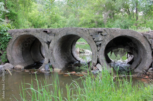 A bridge with concrete pipes to drain water from the river 