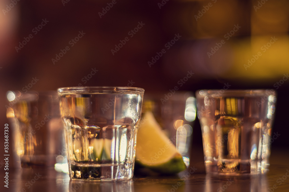 glass of vodka shots on wooden table close up