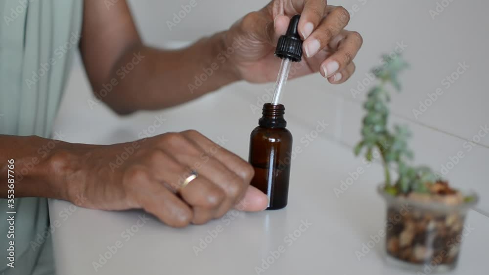 Hands of a black woman applying an organic moisturizing oil. Hands of a black woman applying an organic moisturizing oil.