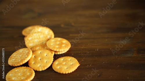 flour biscuit salted cracker rests on a wooden background. The human hand puts on the Board a Cup of tea