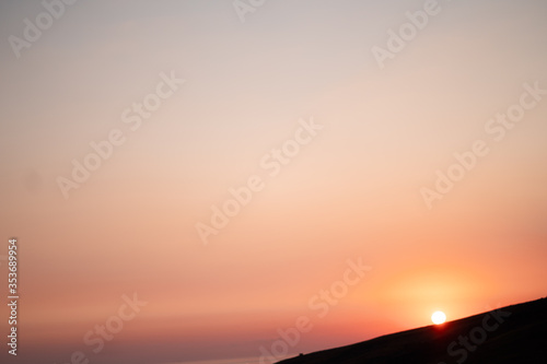 Half of sun was in horizon at the grey colour sea in the twilight. The sunset at the cape. Sunset horizon sea water landscape. Sunset sea horizon panorama. Orange sunset sea horizon view at sunset © MONIUK ANDRII
