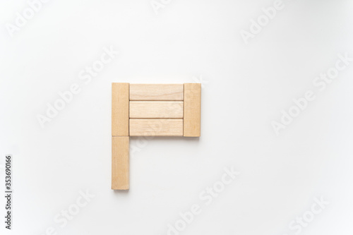 wooden bars lie on a light background in form flag. Selective focus