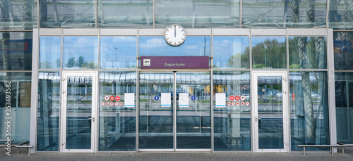 Closed airport glass doors with a Departures sign