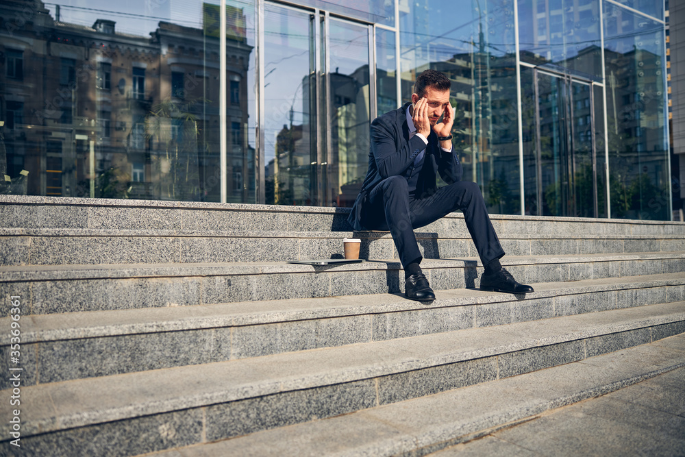 Serious Caucasian male staying outside alone with coffee Serious Caucasian male staying outside alone with coffee
