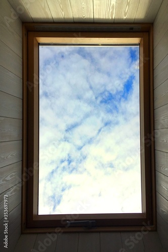 A blue sky with white clouds is visible through the roof window. Template for screen wallpaper  poster  site.