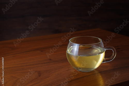 Glass cup of green tea on wooden table