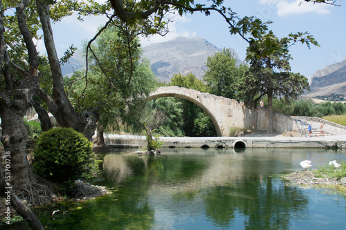 Old Venetian stone Bridge and a small lake with ducks and swans