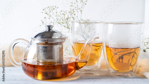 Morning romantic tea for couples. Black tea in regular glass teapot. Hot tea in double wall cups. Double walled mugs.