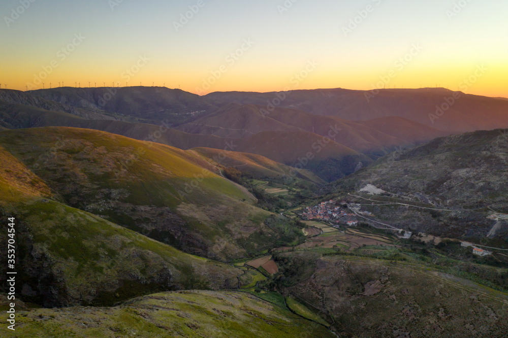 Serra da Freita drone aerial view in Arouca Geopark road with wind turbines at sunset, in Portugal
