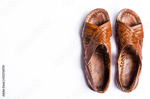 Pair of brown leather traditional Panamanian sandals on white background