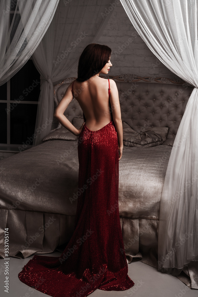 Fototapeta premium Fashion Model Red Dress, Elegant Woman in Sexy Evening Gown, Beautiful Girl Studio Shot on Black Background.Young beauty woman in fluttering red dress.Valentines Day border design.