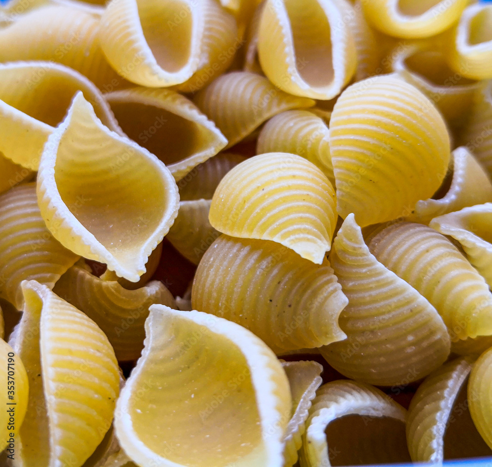 Close up of uncooked shell pasta. Food background. Top view, from above.
