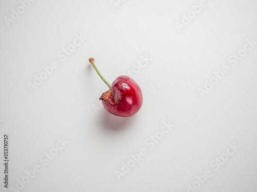 Spoiled fruits of red cherries on a white background
