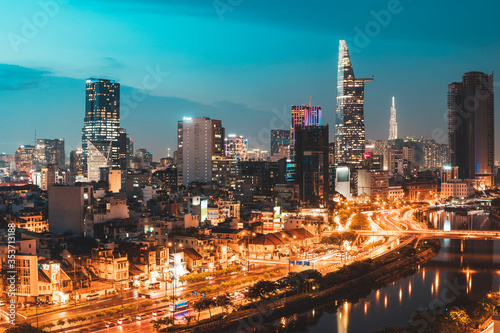 Aerial view of the city skyline of Ho Chi Minh City, Vietnam in late evening with street lights and river