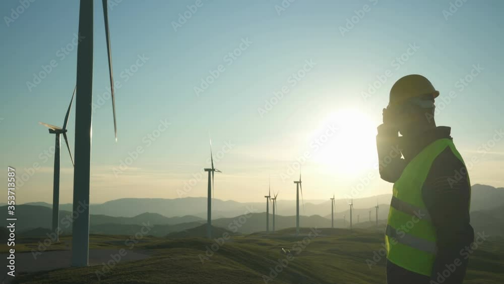 Technician Engineer in Wind Turbine Power Generator Station standing with a tablet in his hands Technician Engineer in Wind Turbine Power Generator Station standing with a tablet in his hands