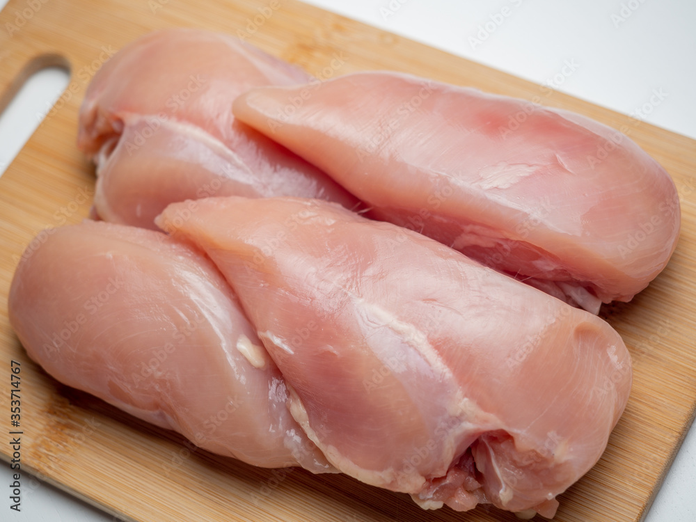 Fresh chicken fillet on a wooden board Fresh chicken fillet on a wooden board