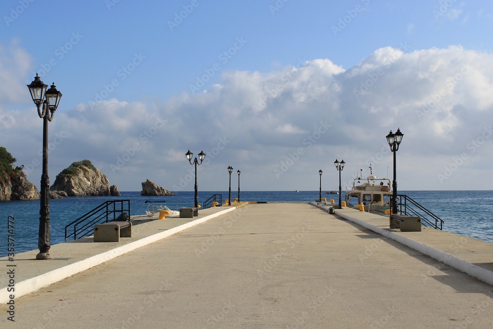 Pier in Parga port empty without people and only one boat, in Preveza Greece at summer