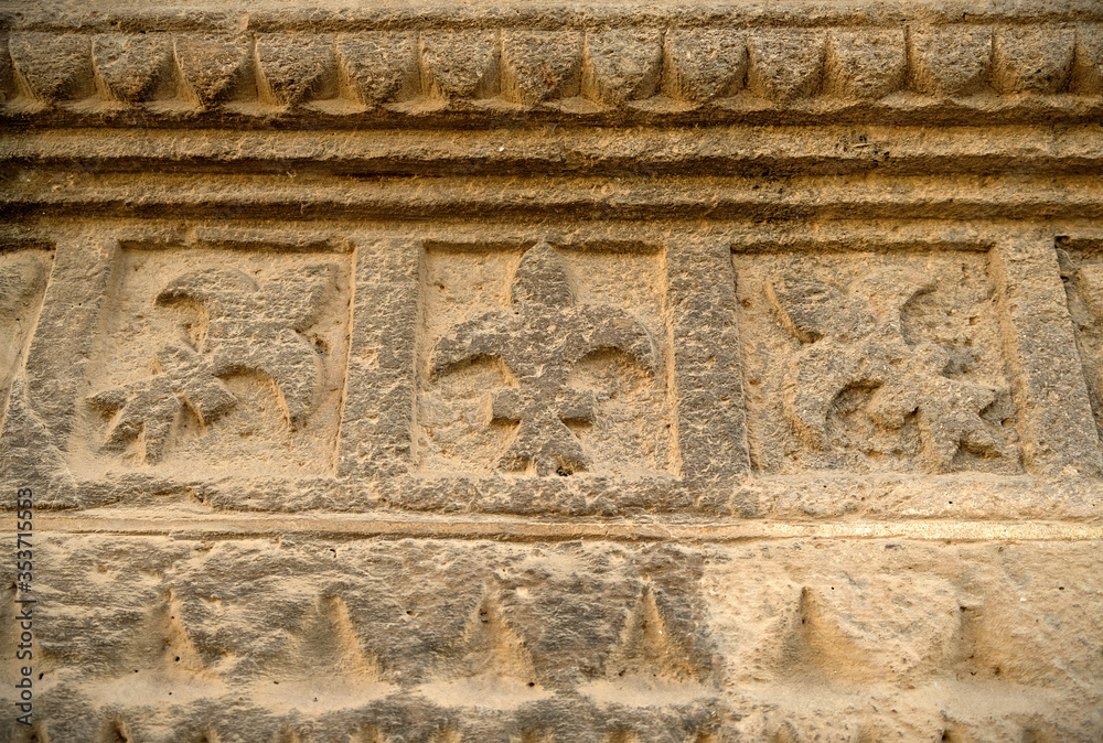 Lyllies carved in golden sandstone relief.