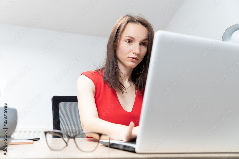 business and beautiful woman in a red dress working in the office at the computer business and beautiful woman in a red dress working in the office at the computer
