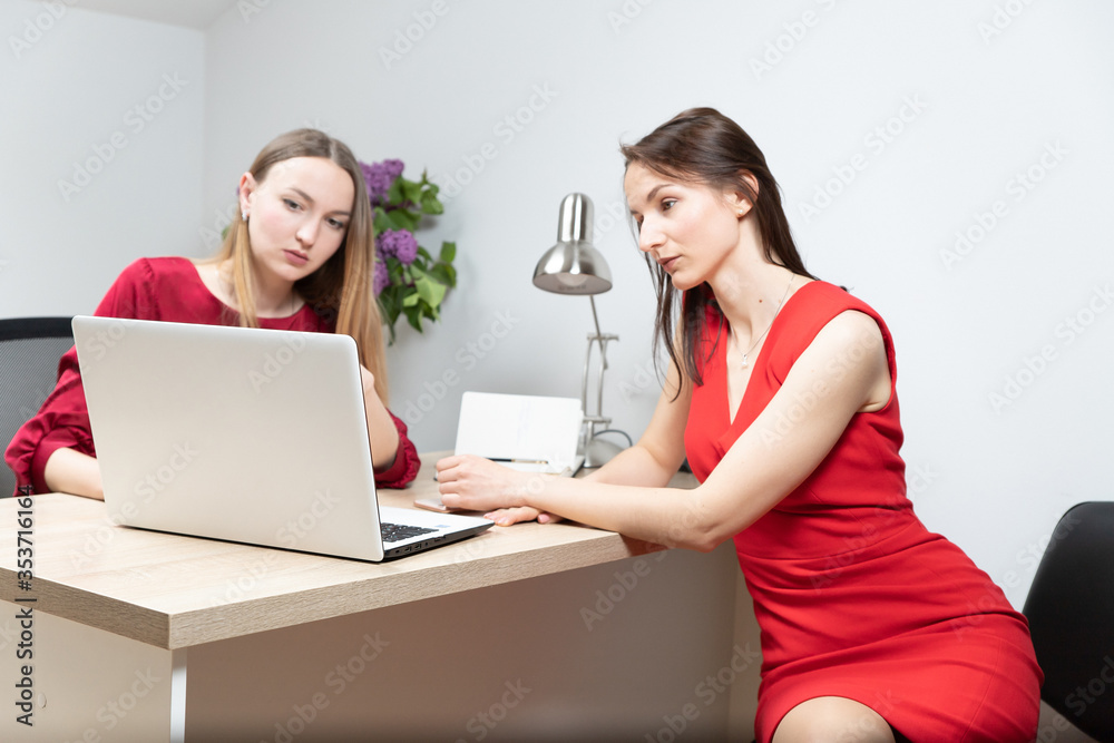 business and beautiful woman in a red dress working in the office at the computer business and beautiful woman in a red dress working in the office at the computer