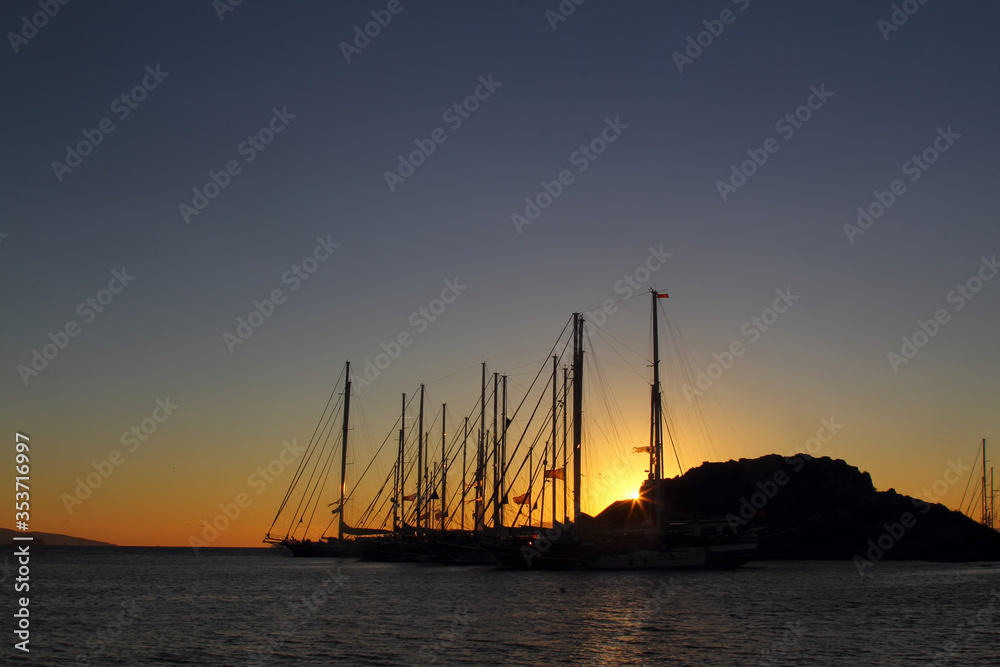 Sailboats on the background of the sunset over the sea