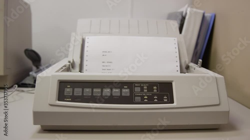 Old 9-pin dot matrix printer prints on perforated paper photo