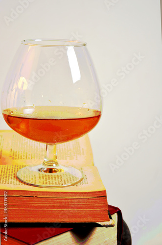 bicchiere di cognac brandy bourbon wisky su vecchi libri photo