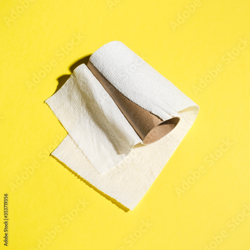 Used up roll of toilet paper on yellow background